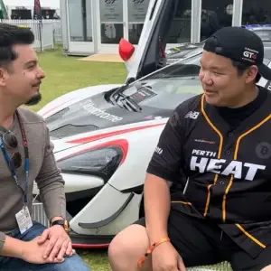 Two people talking beside a car in the paddock